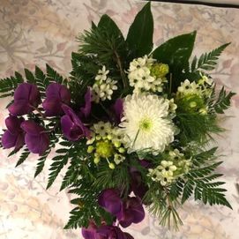 Hautajaiskimppu valkoisilla ja violeteilla kukilla